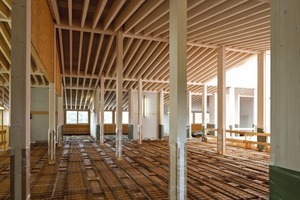  Speziell entwickelte und optimierte Rippendecken aus Brettschichtholz in Holz-Beton-Verbundbauweise sorgen für eine optimale Akustik in den Lehrräumen. Zusätzlich schaffen die Decken aufgrund der recht großen Speichermasse eine verbesserte Wärmekapazität. Über der Decke liegt ein 10 cm dicker Estrich. Auch er dient als Speichermasse und wird über eine Fußbodenheizung zum Heizen und Kühlen aktiviert 