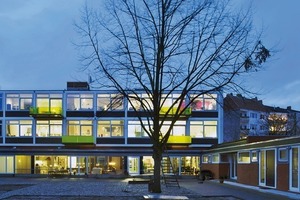  Neue Wohnungen in den ehemaligen Klassenräumen. Die gelben Balkone sind ein sichtbares Zeichen für die neue Nutzung 
