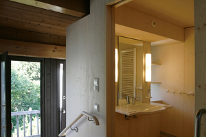 Obwohl das Bad innenliegend ist, strömt Tageslicht in den Raum – durch kleine Fenster neben dem Waschtisch. Zudem reflektiert die helle Farbe Gelb des PVCs ein angenehmes Licht 