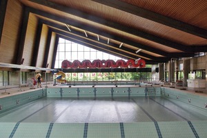  Die Schwimmhalle vor der Sanierung: Das Tageslicht wird von den dunklen Deckenflächen geschluckt, die nach der Sanierung hell und frisch erscheinen 