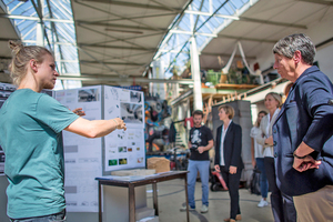  Projektleiter Christian Brosig präsentiert Bundesbauministerin Dr. Barbara Hendricks Steckverbindungen, mit denen die Wandmodule verbunden werden 