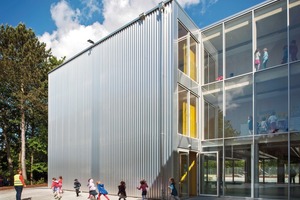  Die Trapezbleche der Fassade aus glänzendem Aluminium spielen mit dem Container-Zitat auf die temporäre Nutzung des Schulbaus an 