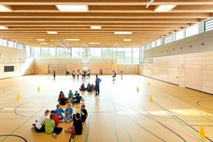  Die Zweifeldsporthalle im Erdgeschoss ist aufgrund der Topografie des Geländes teilweise in den Hang geschoben. Sie orientiert sich zum Lärmschutzwall hin 