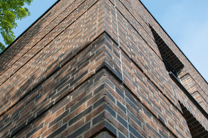  Der Architekt wählte für die Fassade den „Original Wasserstrich Backstein Klinker“ von Hebrok in der Farbgebung „terra“. Der dunkle Stein ist dabei teilweise in Fußsortierung eingesetzt, sodass das Fassadenbild lebendiger wirkt. Dabei werden die sonst nicht sichtbaren Rückseiten der Steine, die produktionsbedingte Abdrücke haben, zur Fassadengestaltung genutzt 