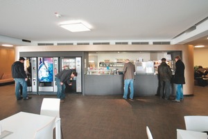  Lounge- und Arbeitsbereich werden nicht nur räumlich, sondern auch durch Material und Licht getrennt: funktionale Holzarbeitstische in Weiß treffen auf eine weiche Sitzlandschaft in warmen Farben. Je-doch wird durch die Kontinuität der Decke und des homogenen Parkettbodens der gesamte Raum zu einer Einheit gebracht 