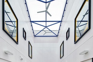  Der tief gestaffelte Innenraum verfügt über einen von oben belichteten Innenraum, der von den Architekten im Obergeschoss mit einer umlaufenden Galerie zu einem zweigeschossigen Atrium ausgebaut wurde. Der Luftraum ist mit einem Foliendach bedeckt, das in den Luftkollektor eingebunden ist. Der Umgang erschließt die Gruppen- und Nebenräume sowie eine geräumige Dachterrasse, die für die U3-Gruppen als geschützte Außenspielfläche dient 