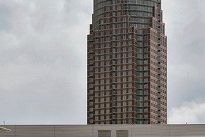  Im Hintergrund Messeturm und -hallen. Die Untersicht offenbart die Holzeindeckung des Stahlrostes mit den gezielt gesetzten Öffnungen für mehr Tageslicht, das von zahlreichen Downlights ergänzt wird 