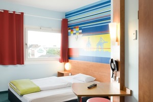  Die Ausstattung des Hotels ist einfach und funktional. Die Zimmer mit den schlichten Holzmöbeln werden durch die abstrahierten Hamburg-Grafiken über dem Kopfende der Betten aufgepeppt  